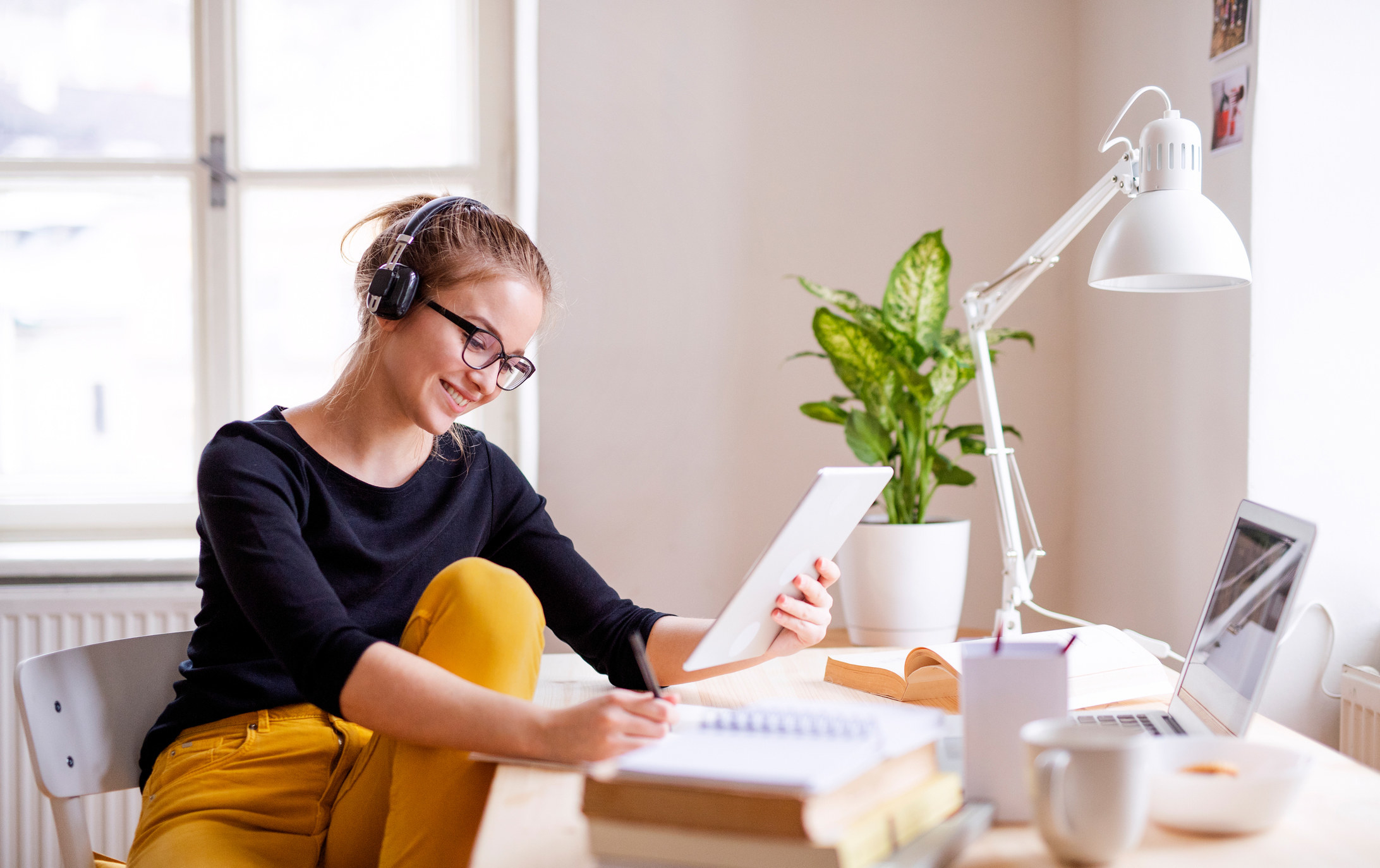 A college student happily completes assignments at their desk