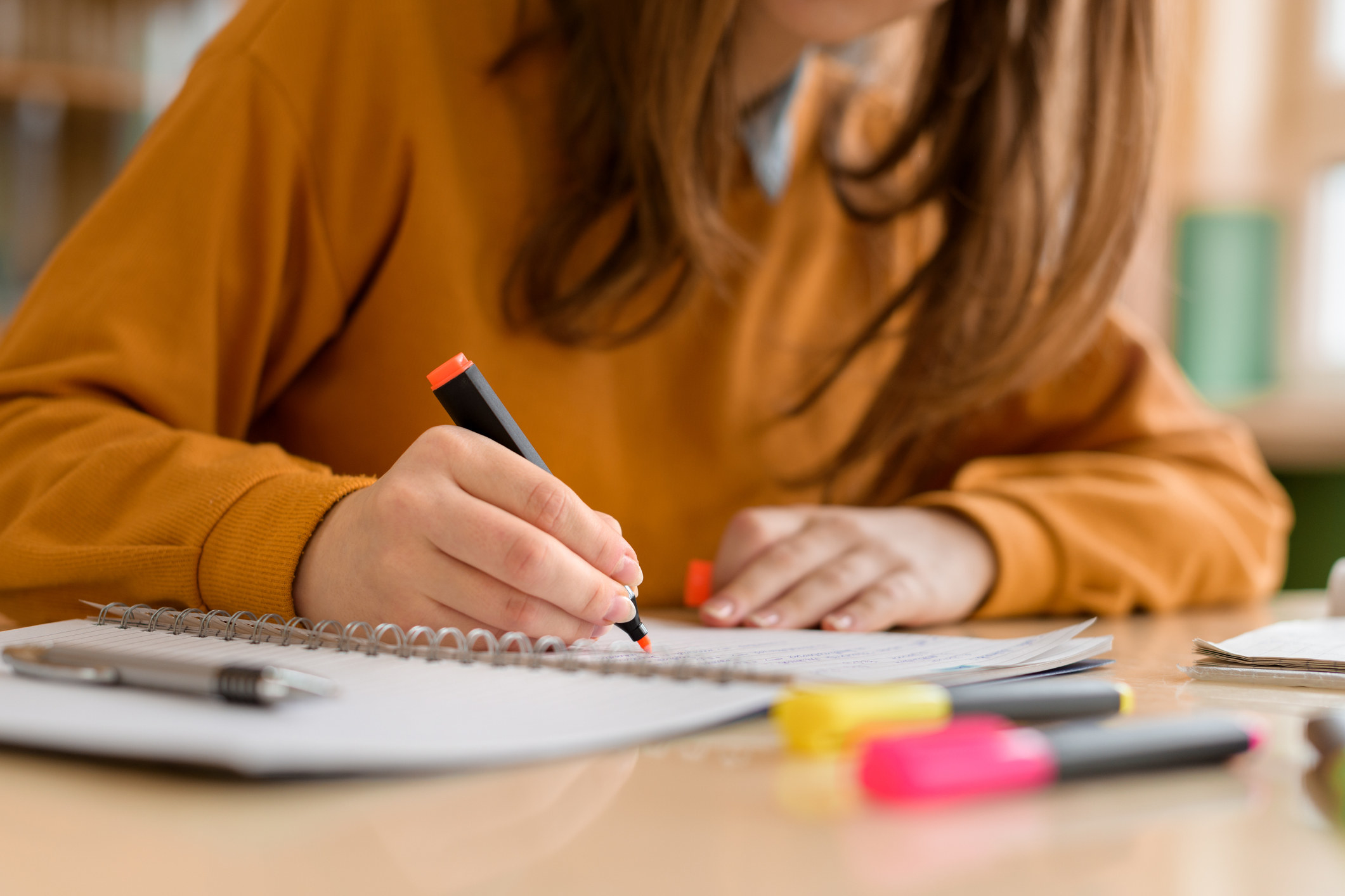 A student highlights their notebook while taking notes