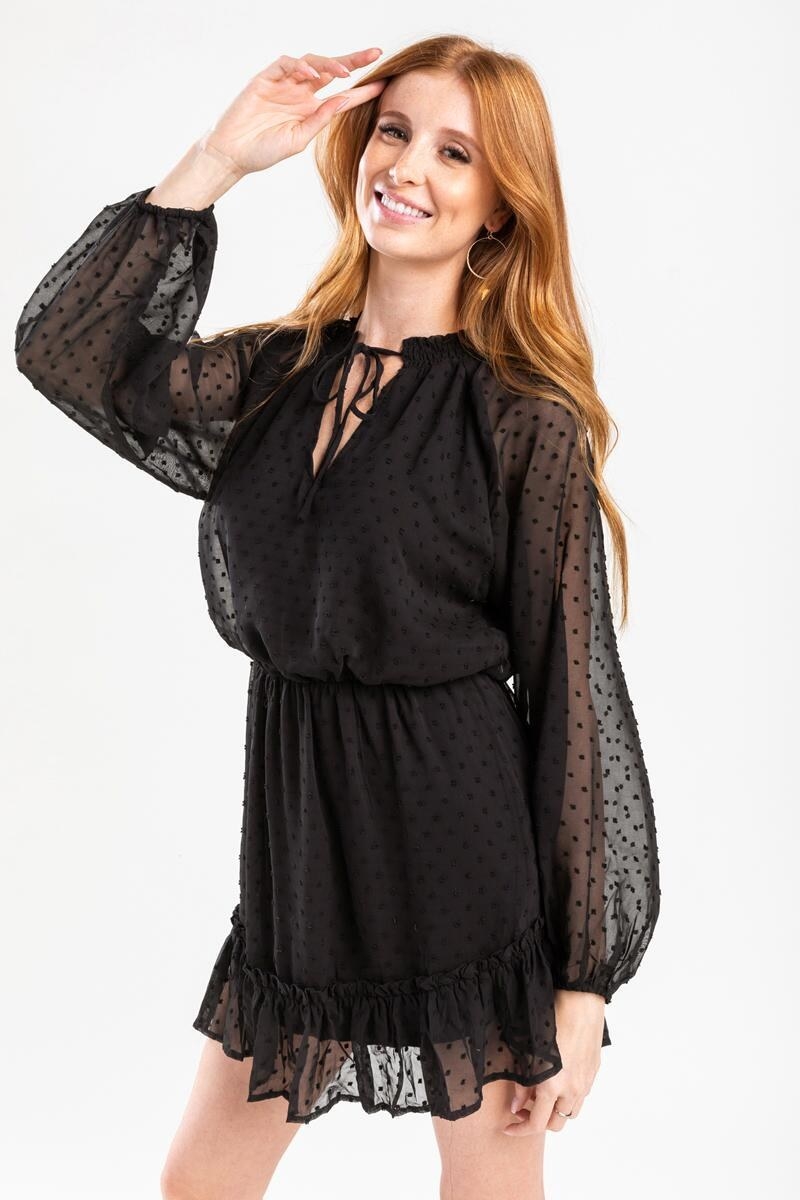 a model in the black dress with long bubble sleeves and a tiered hemline