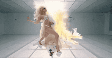Lady Gaga posing in front of a fire