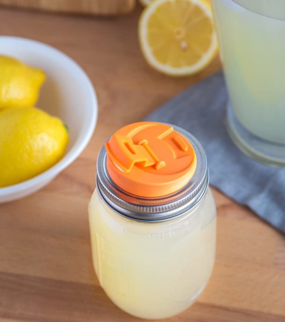 A mason jar filled with lemonade and the drink lid attached to the top