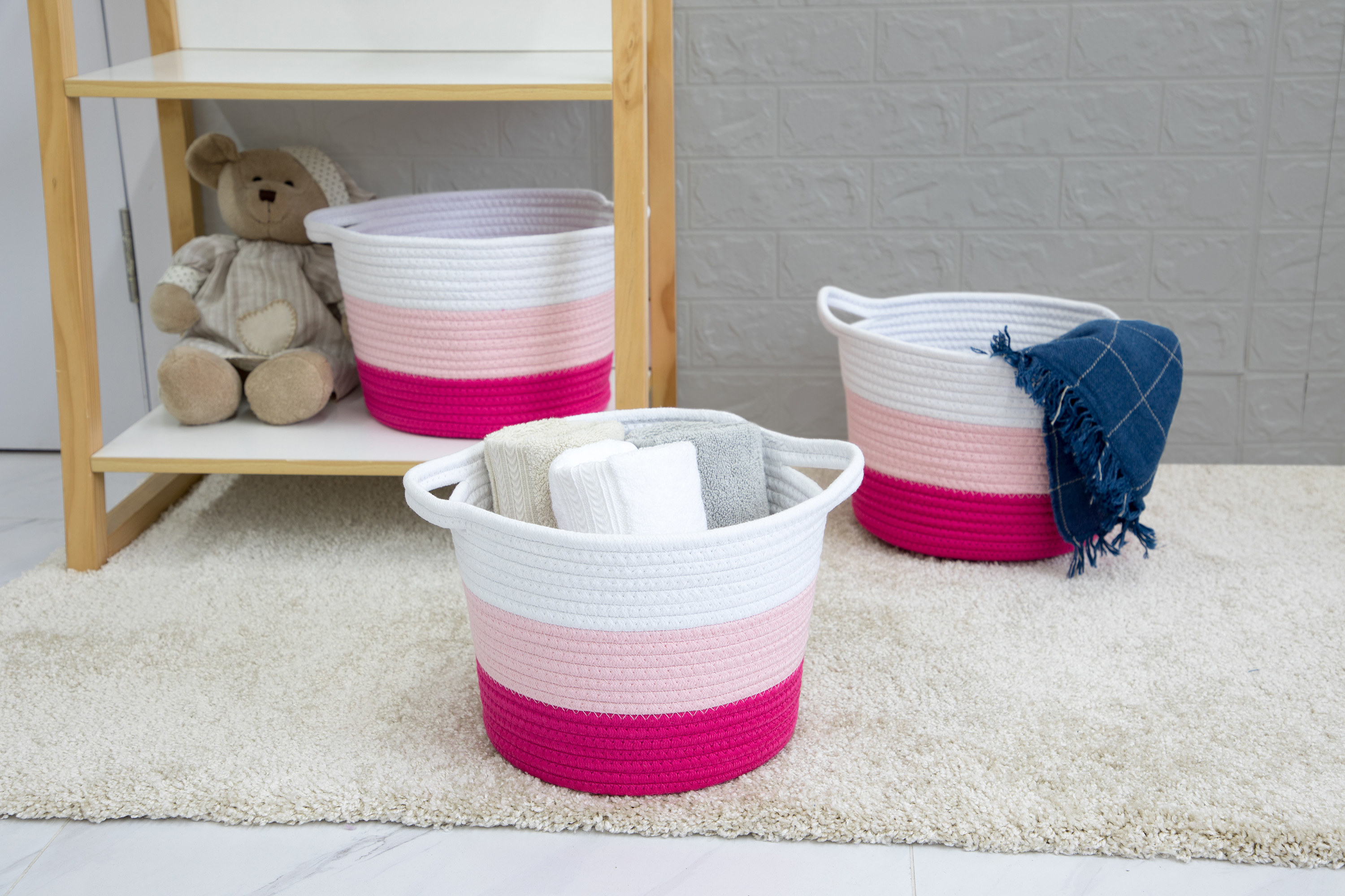 three pink storage baskets in children's room