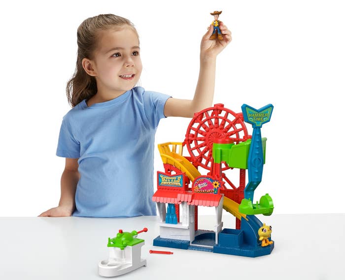 girl playing with toy story carnival set