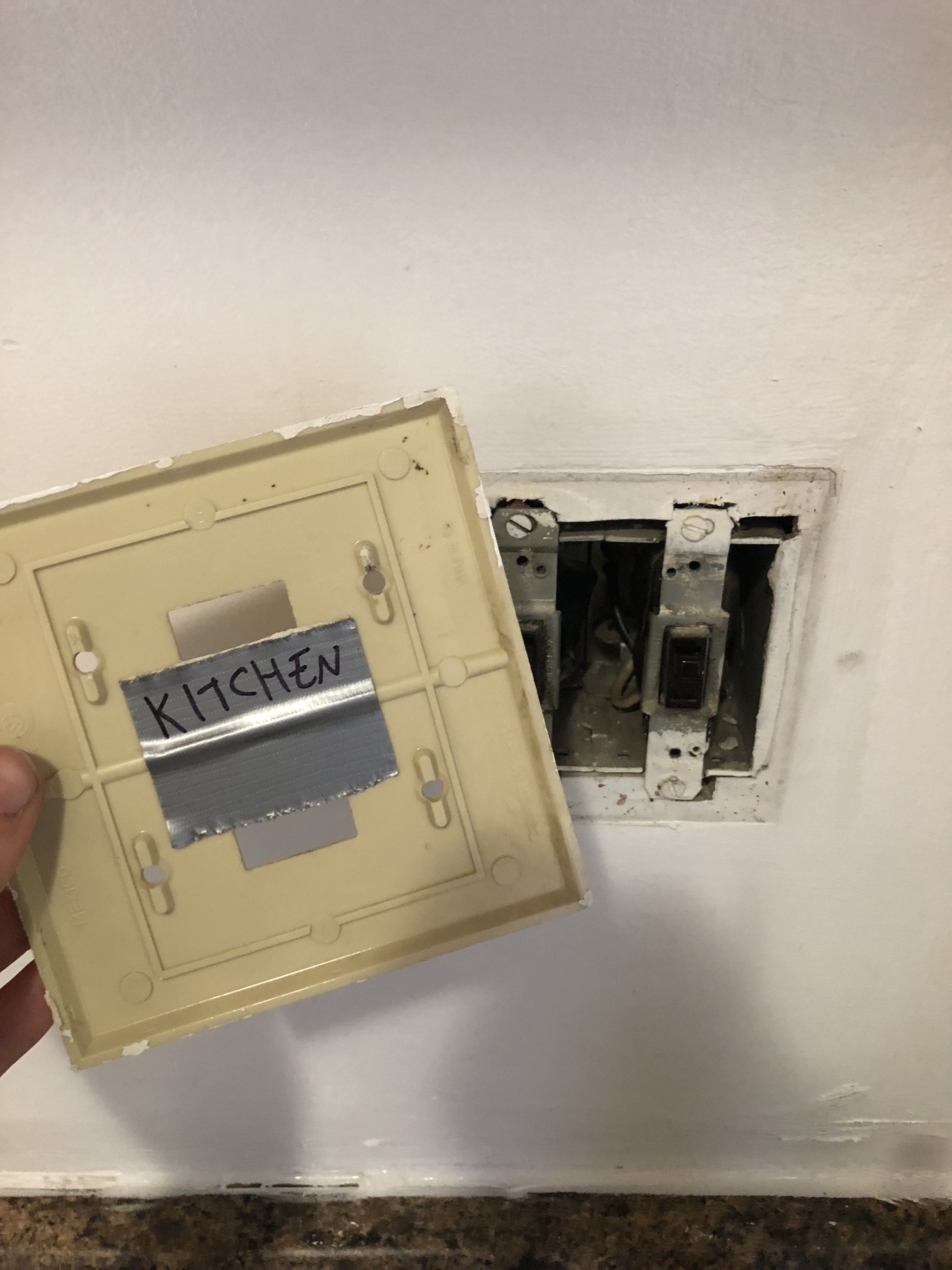 old mismatched switchplate being removed from the wall