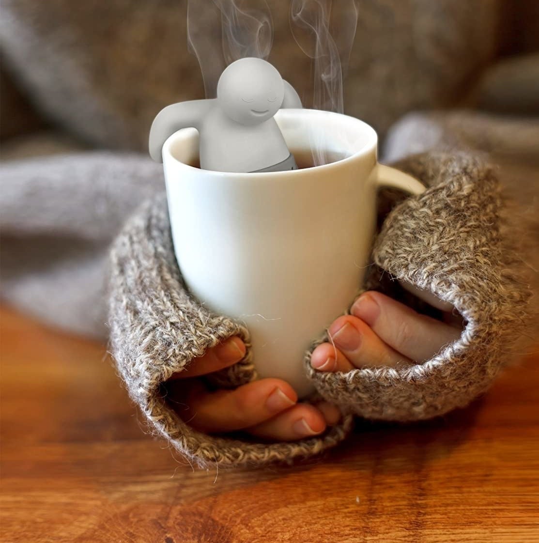 model holding mug with white tea infuser inside