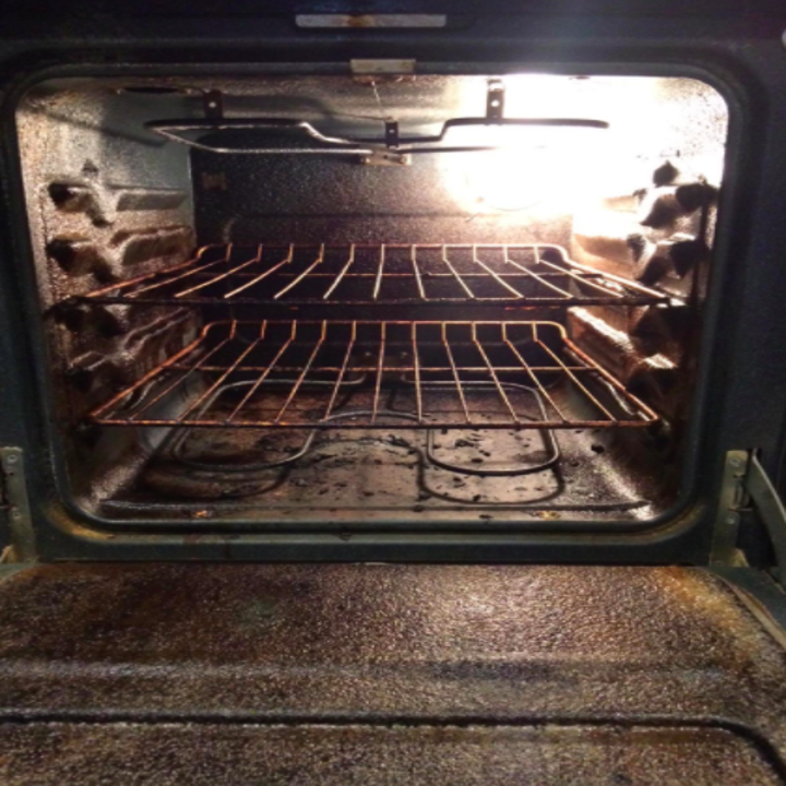 Reviewer photo showing their oven covered in grease and burnt food scraps, prior to using Easy Off Professional Oven Cleaner 