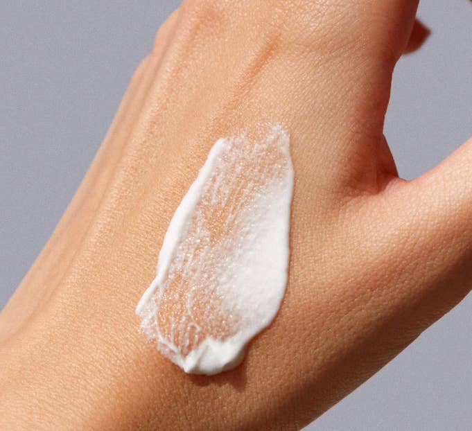 A model&#x27;s hand showing the texture of the cream