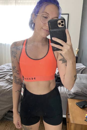 a reviewer in a bright orange sports bra