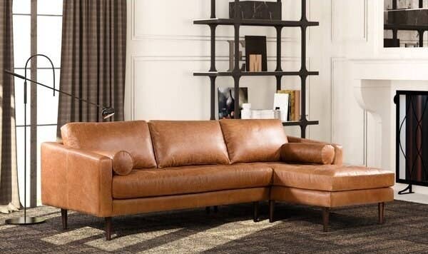 Mid century modern sofa in tan leather with two round arm rest pillows. Sits three with sectional. 