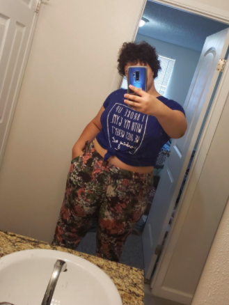 Reviewer wears same style joggers in a dark green and pink floral print with a dark blue T-shirt