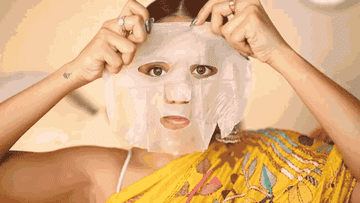 Model applies clear papaya and pineapple face masks to their face 