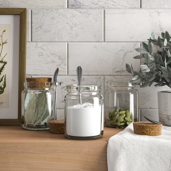 Three glass jars with cork tops and small spoons that fit in a glass attachment on the top of the jar 