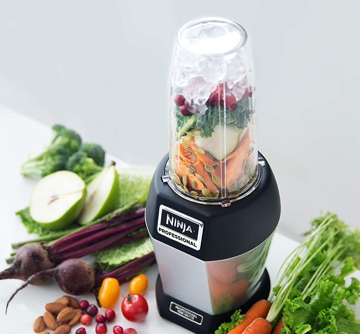 A Ninja blender filled with fruits and veggies