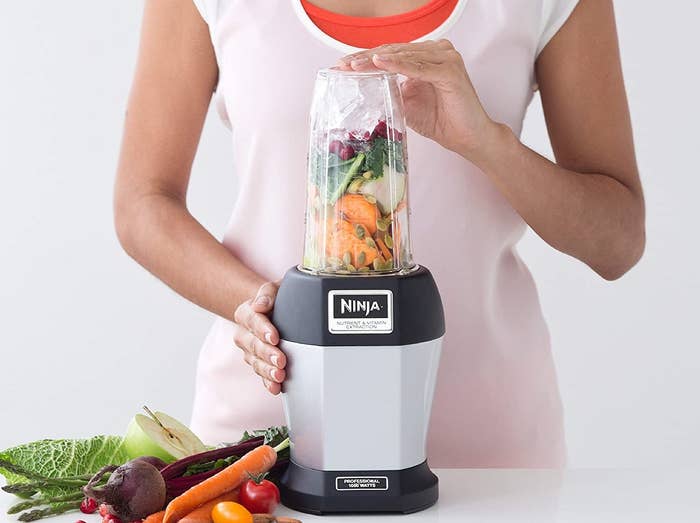 A person blending a fruit and veggie smoothie in the Ninja blender