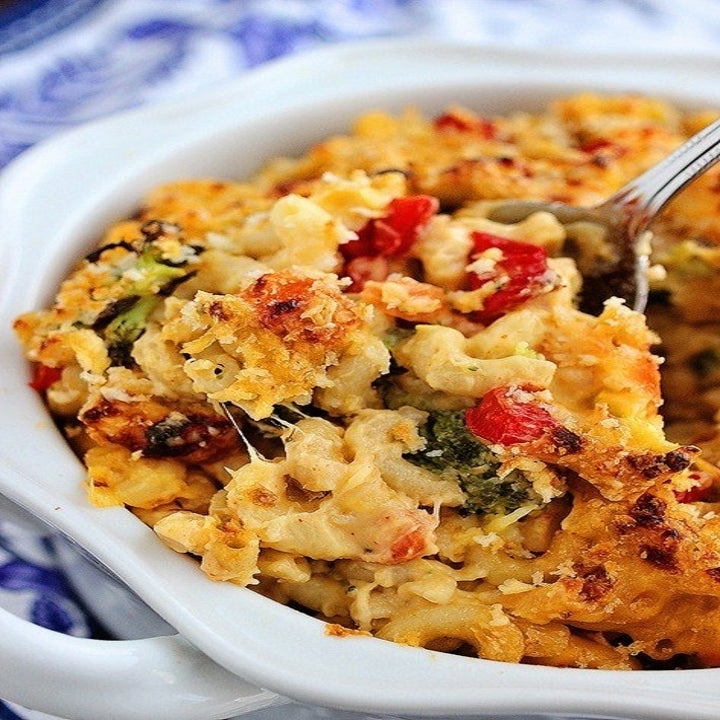 A bowl of vegetable mac 'n' cheese with a crispy cheesy layer on top.