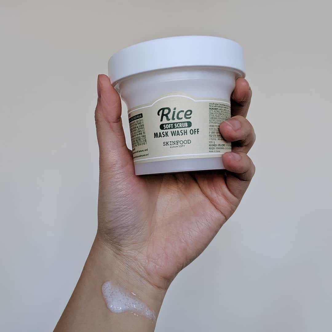 A person holds up the tub of the rice mask