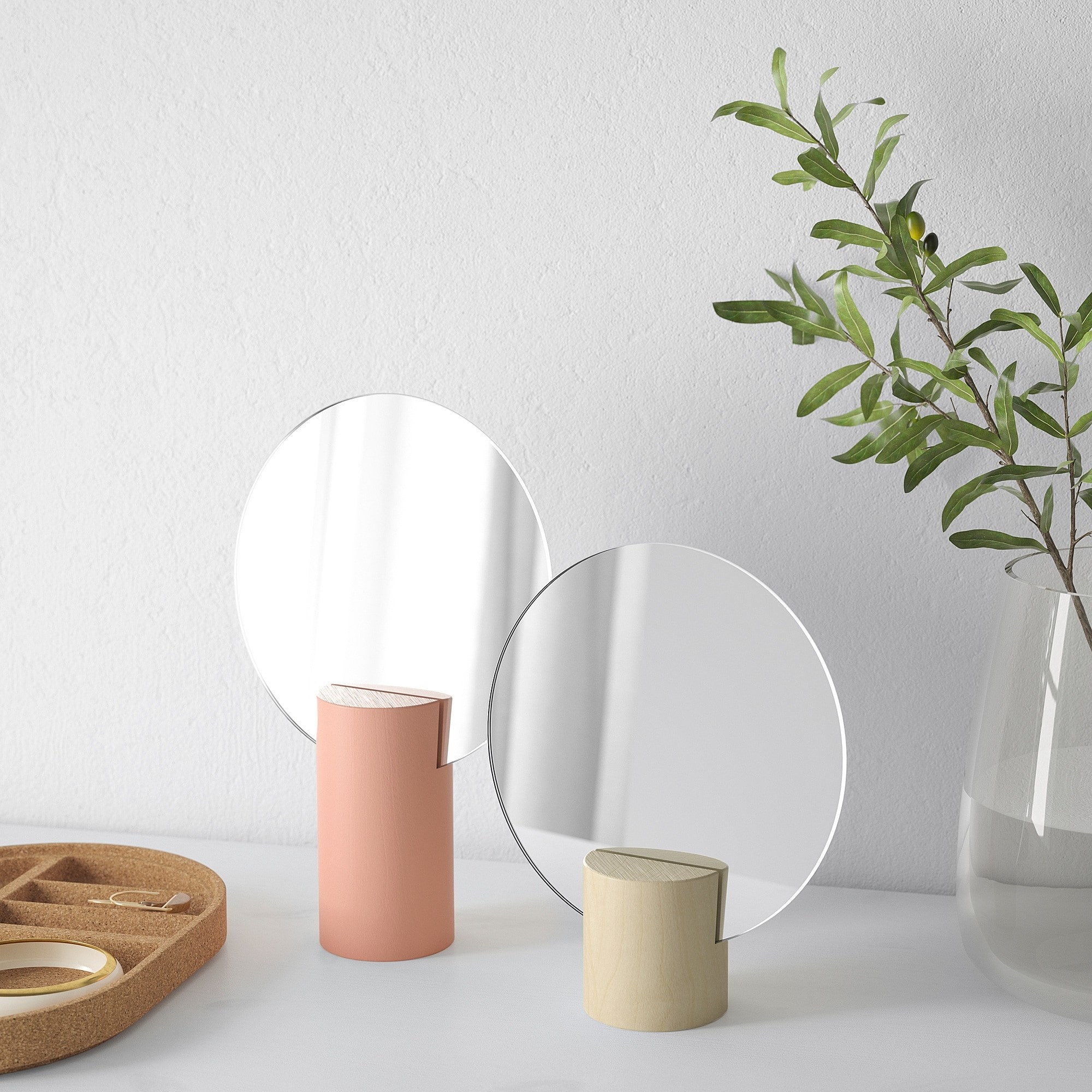 Two circular mirrors with wood bases in pink and beige