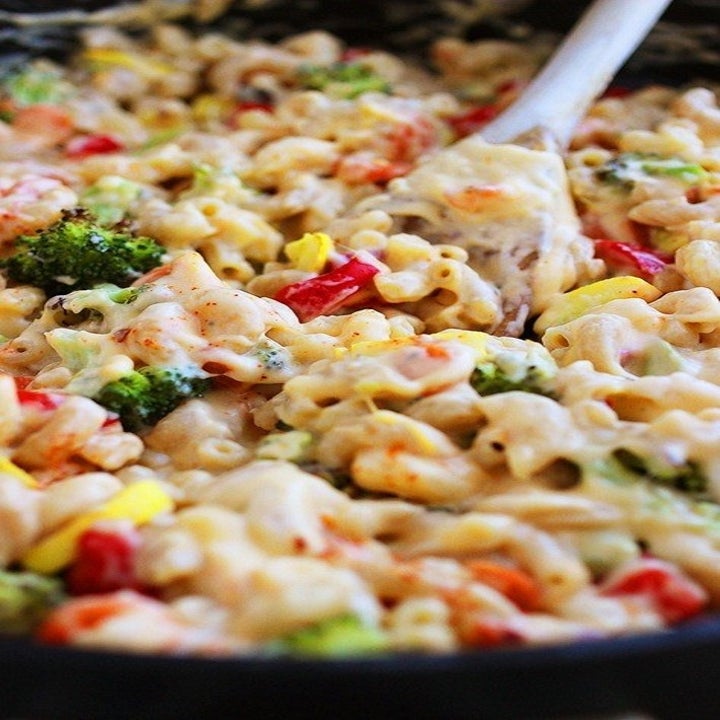 A pan of mac 'n' cheese loaded with roasted pepper, broccoli, squash, and more veggies.