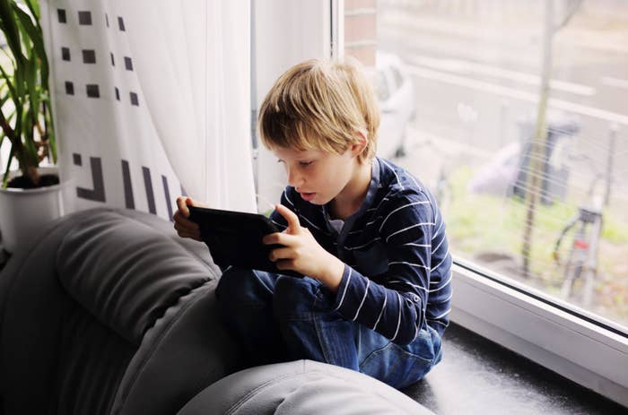 Young boy looking at iPad while learning from home.