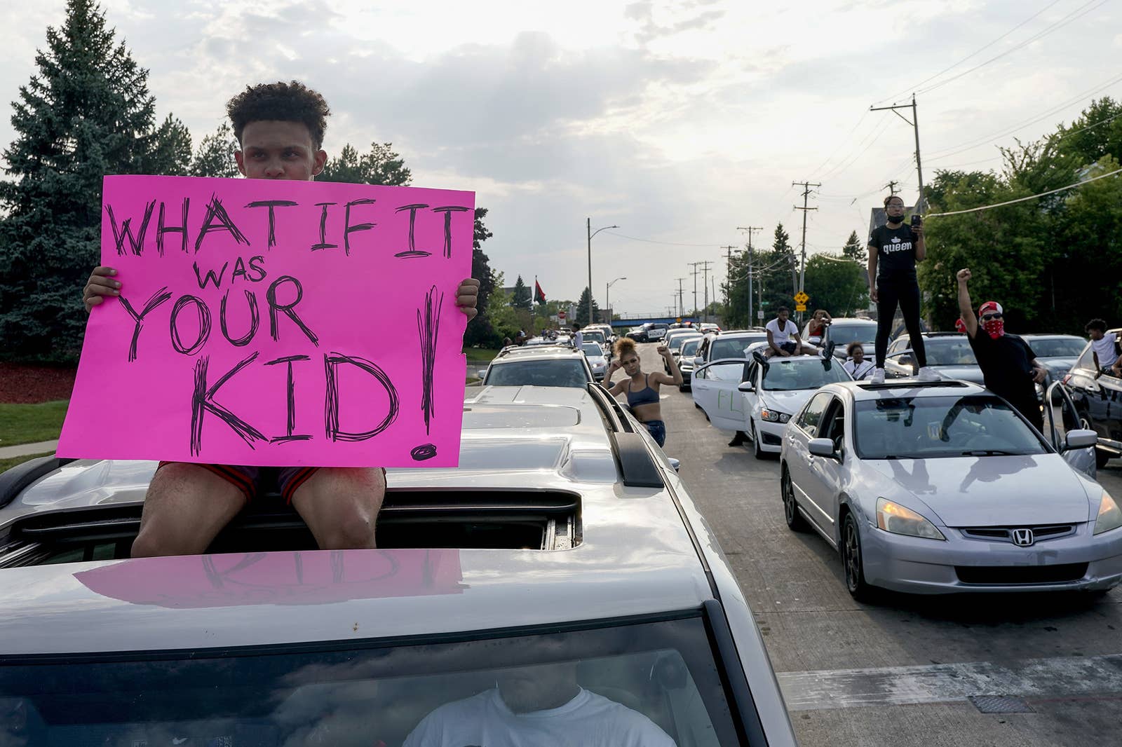 A protester with a sign that says &quot;what if it was your kid!&quot;