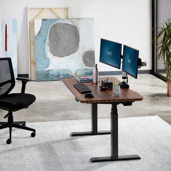 a walnut table top desk with legs that adjust electronically