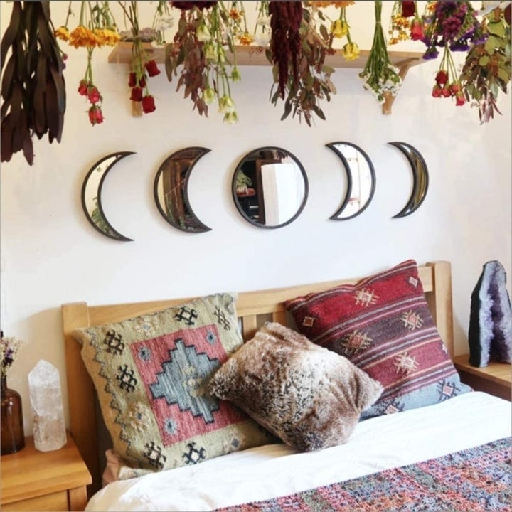 Five stick-on wall mirrors in growing crescent moon shapes on either side. Circular mirror in middle. 