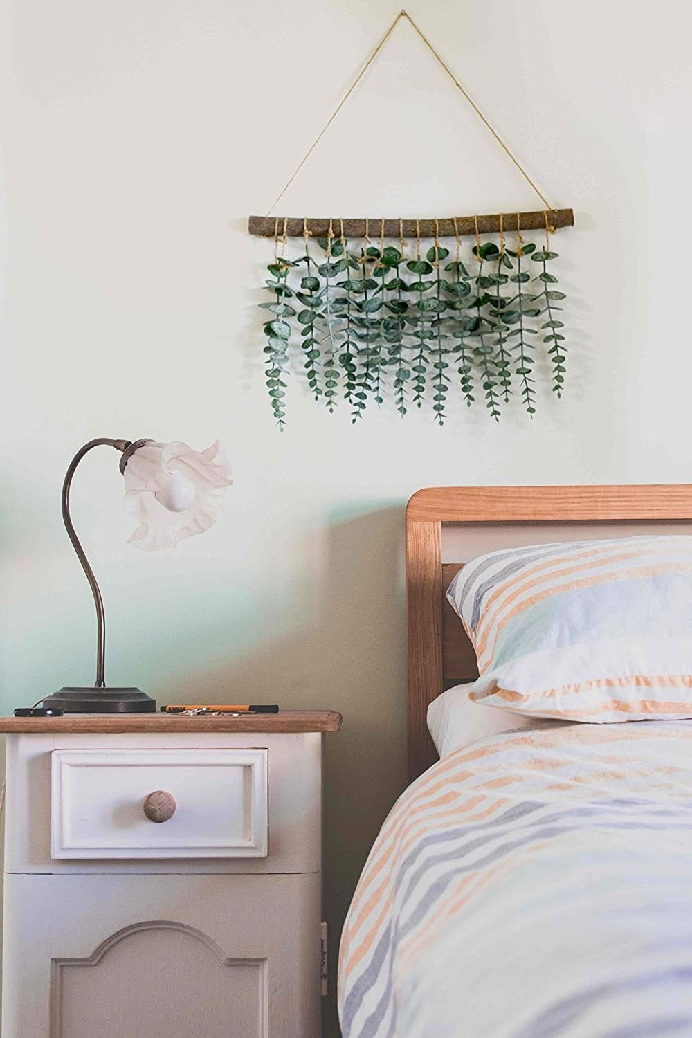 Line of small eucalyptus leaves hanging from a branch on a string