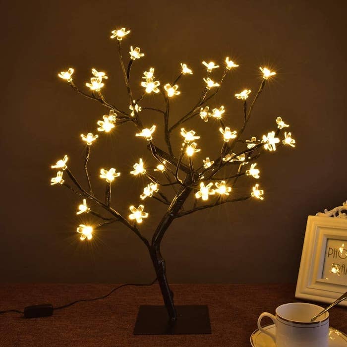 A tree with LED cherry blossoms is lit on a table