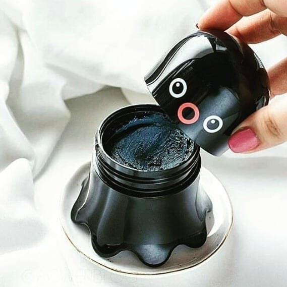A person taking the cap off the octopus-shaped blackhead solution bottle