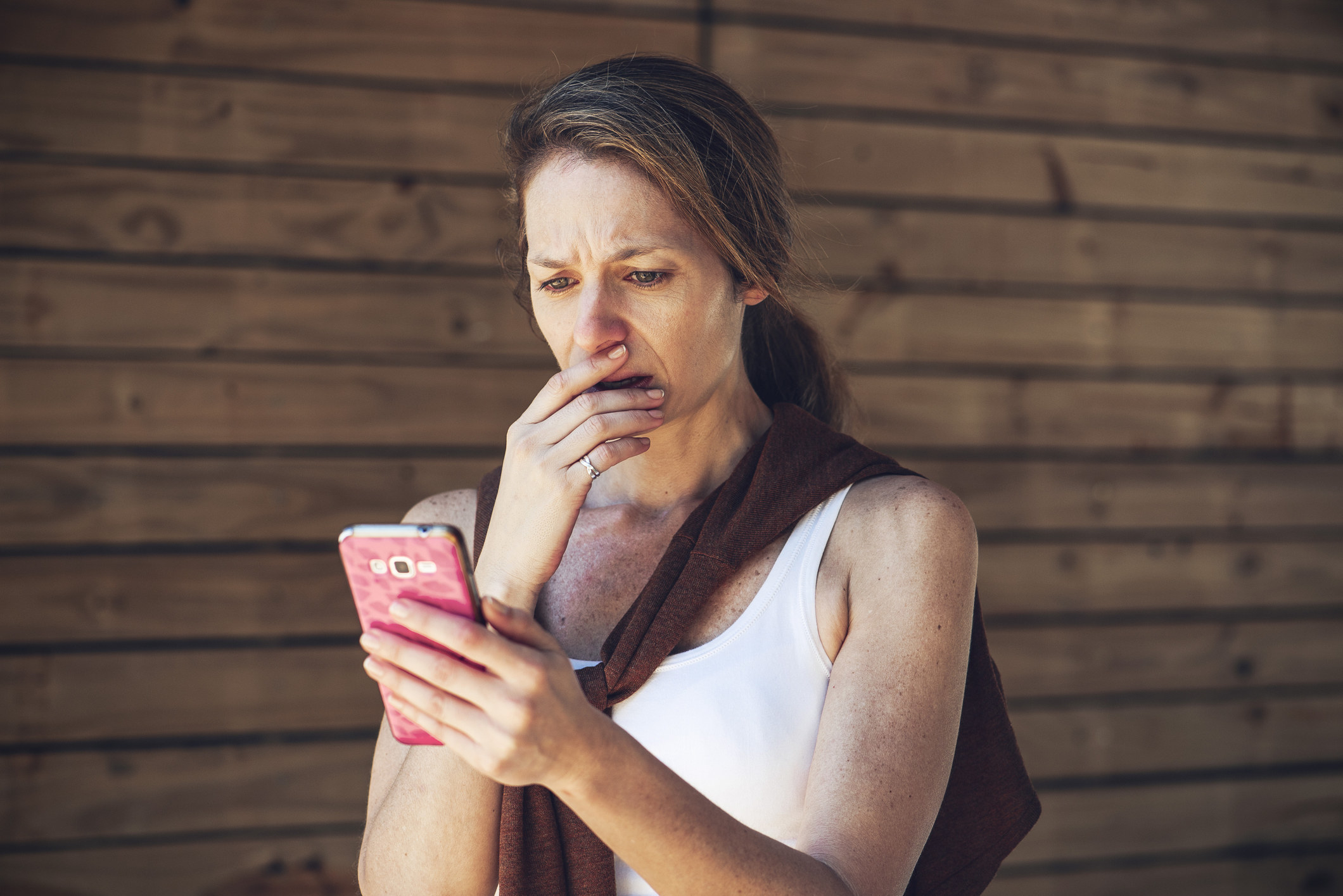 Woman looking at phone, shocked