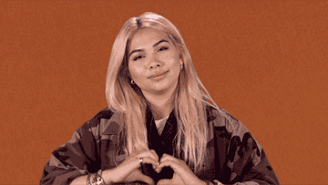 GIF of a woman doing heart hands