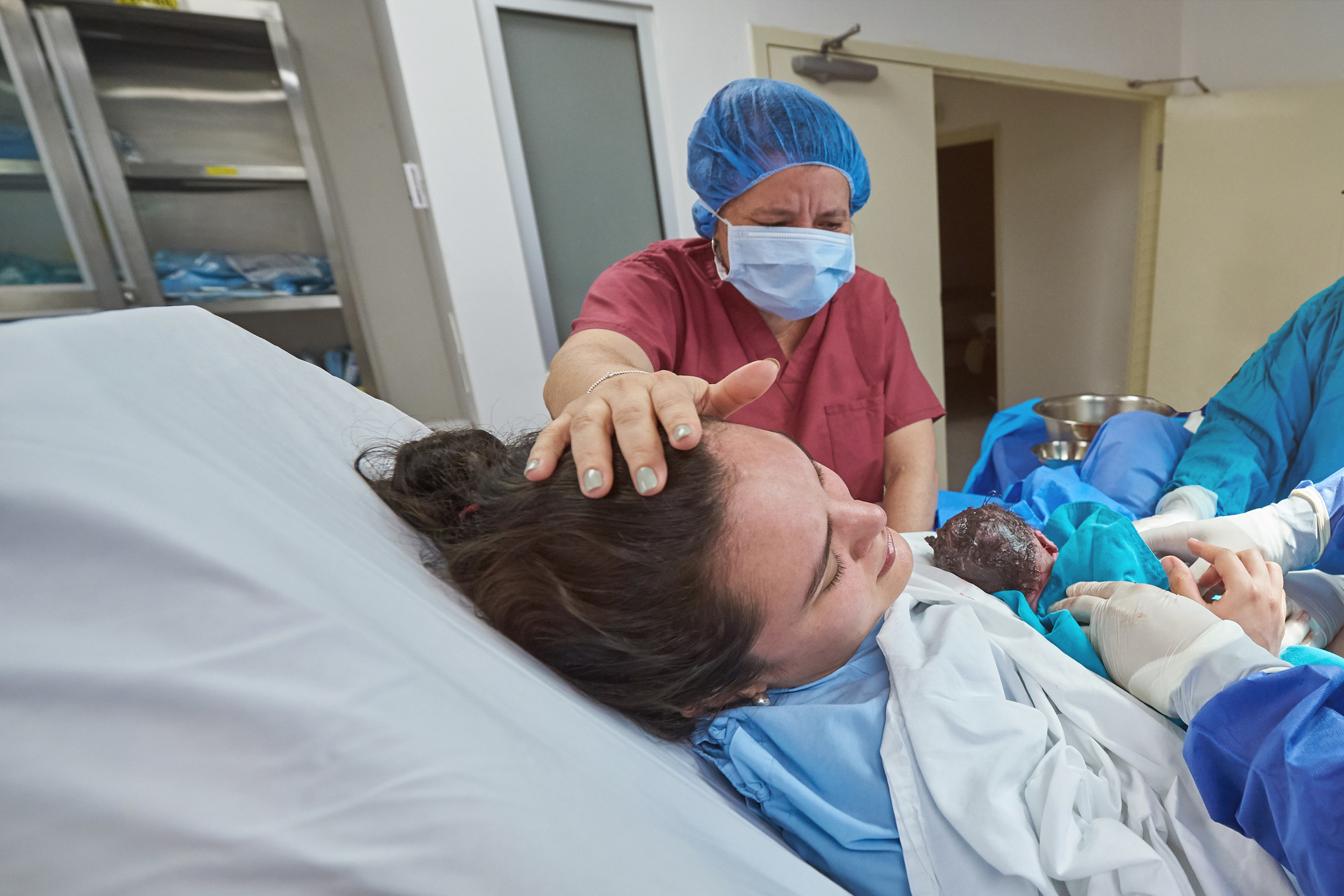 一位年轻女子在医院床上抱新生儿
