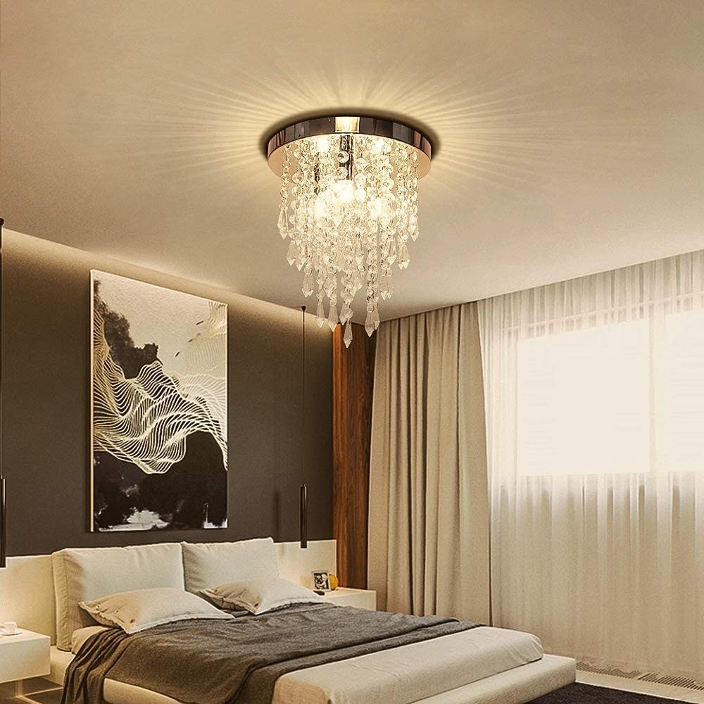 A chandelier with strings of crystals hang in a bedroom