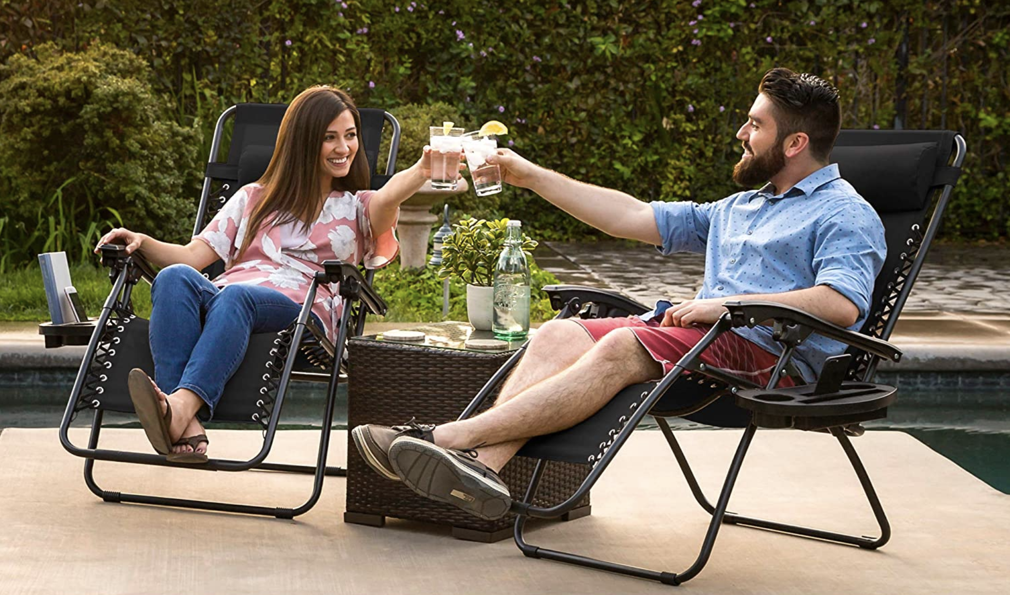 Two models in black recliners with objects in their drink holders 