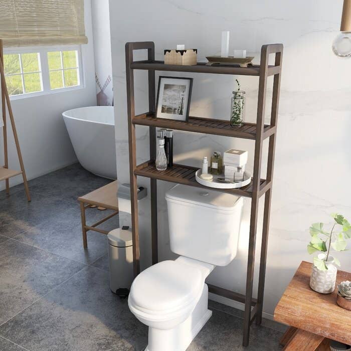 The 28&quot; W x 60&quot; H Over the Toilet Storage in espresso in a staged bathroom