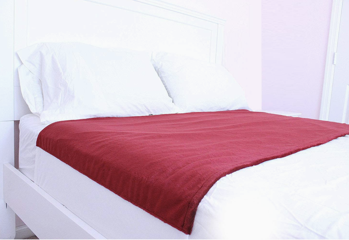 red sheet protector on top of bed sheets