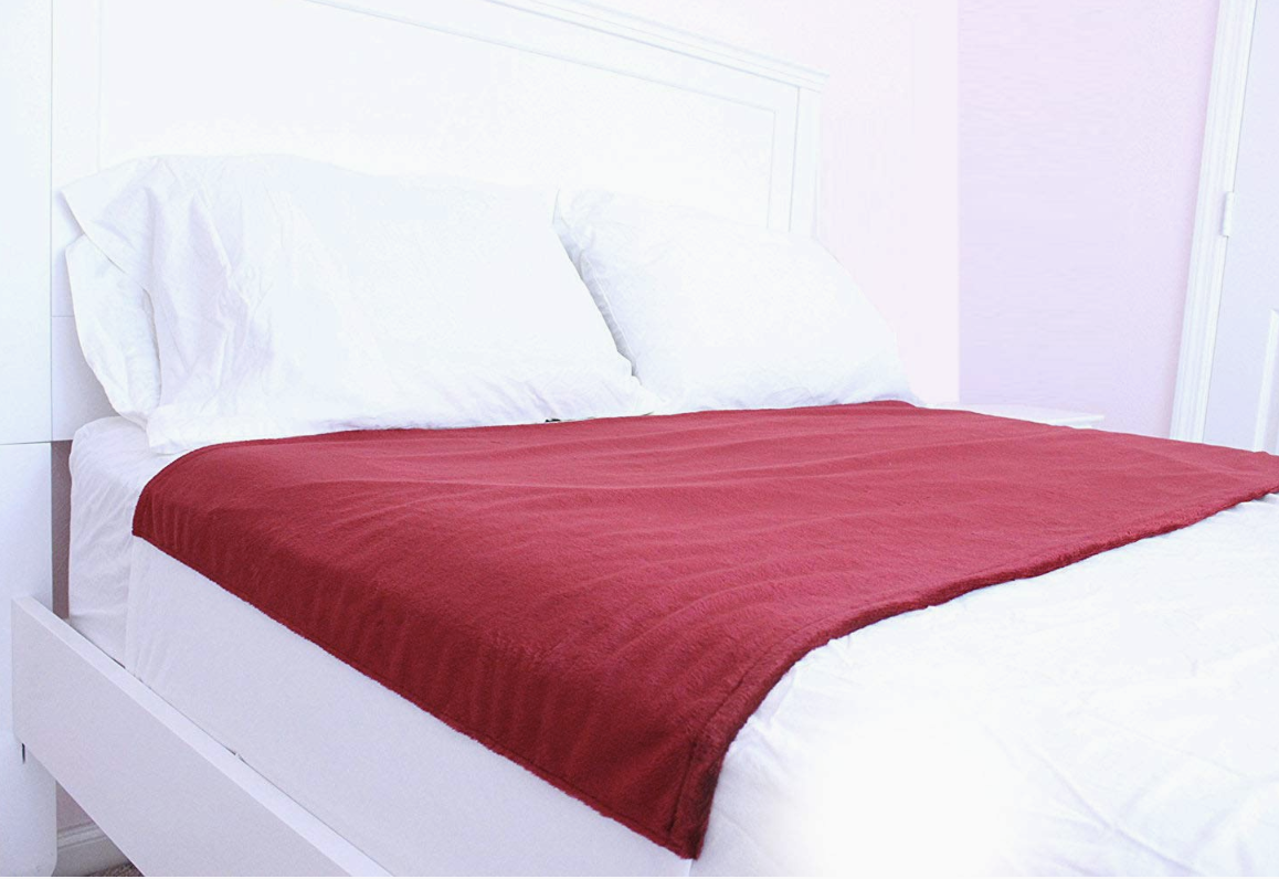 red sheet protector on top of bed sheets 