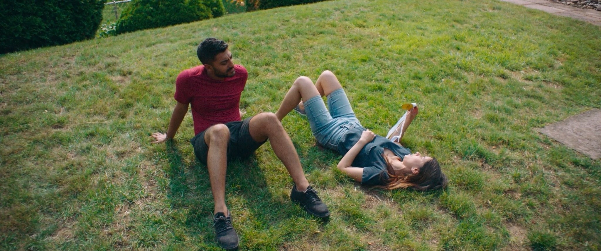 Sonny and Monica sitting in grass in Definition Please