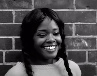 Azealia Banks stands against a brick wall