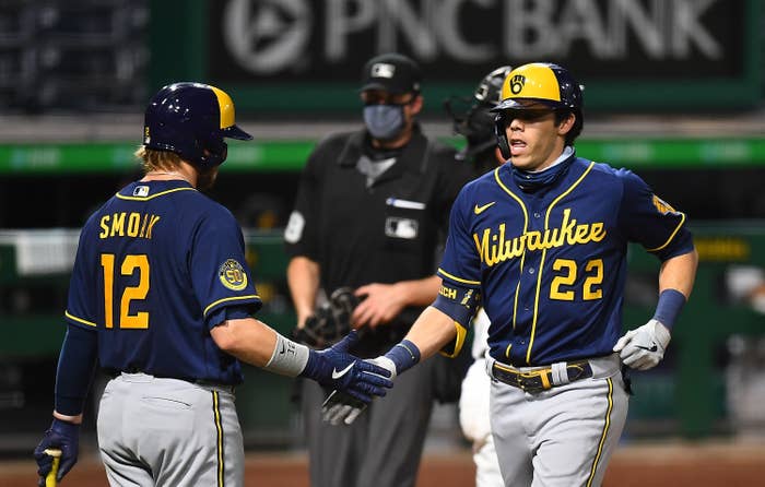 Two Milwaukee Brewers players high-five during a game