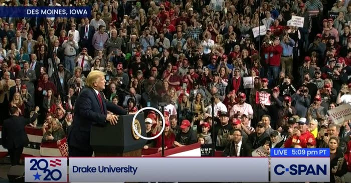 Trump speaks behind a lectern at a rally; a white circle focuses on a boy in the front row of the audience