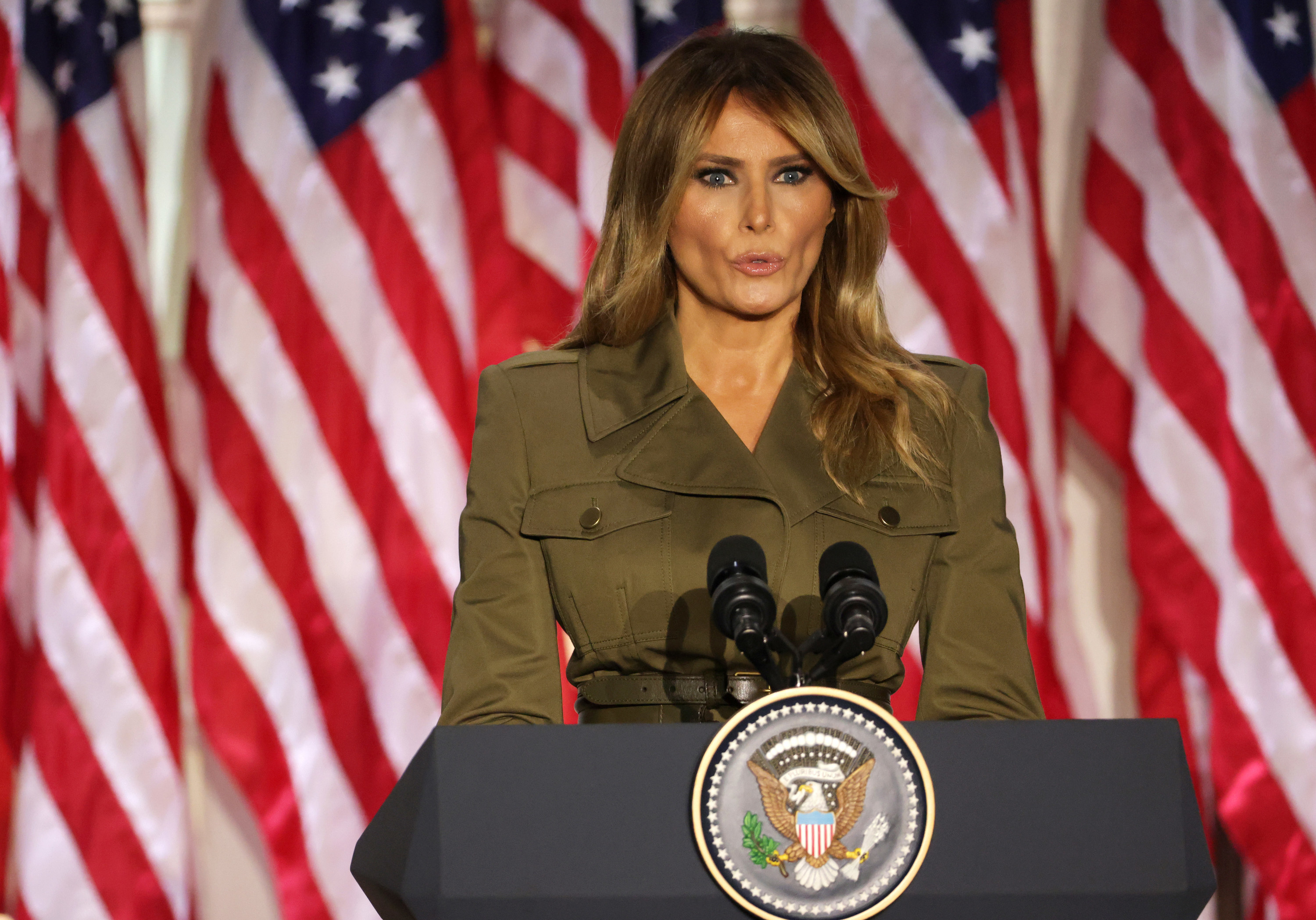 Melania Trump speaks from behind a lectern with the presidential seal on it