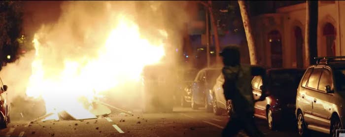 Person running near a fire set in the streets of Barcelona in 2019.