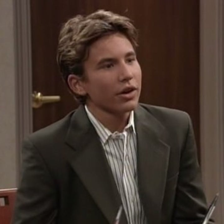 Randy wearing a suit and sitting in a chair on "Home Improvement." 
