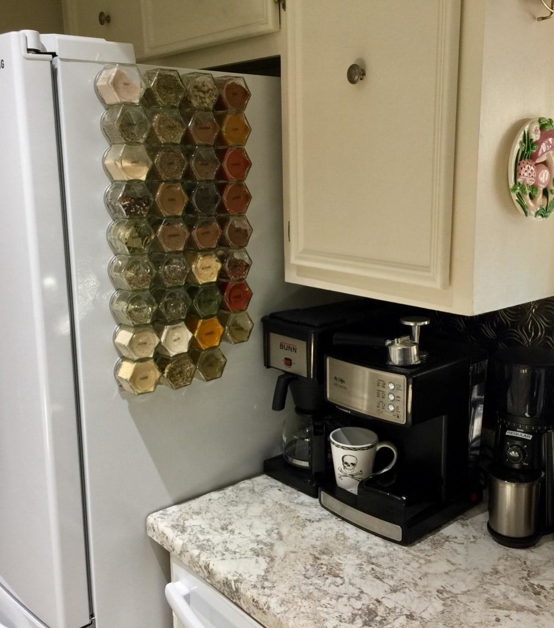 Reviewer pic of a number of glass spice jars stuck to the side of a fridge