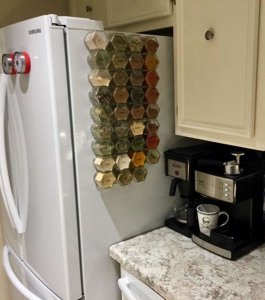 Reviewer pic of a number of glass spice jars stuck to the side of a fridge