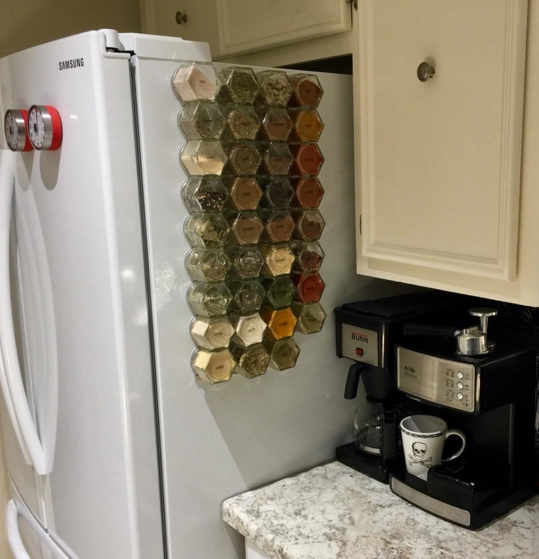 Reviewer pic of a number of glass spice jars stuck to the side of a fridge
