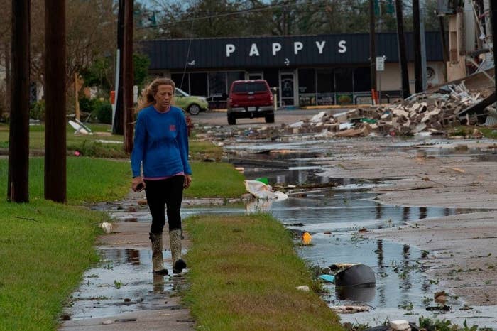 A woman walks down the wreckage of a street hit hard by Hurricane Laura in Lake Charles, Louisiana.