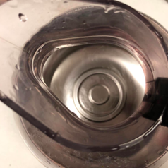 Reviewer photo showing the bottom of the same coffee pot after using Bottle Bright, revealing all the build-up is gone and you can see the clean, stainless steel bottom is clean and shiny 