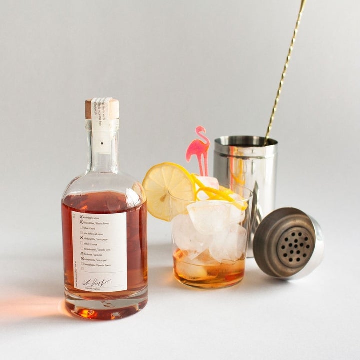 a bottle of a diy gin cocktail next to some of it poured into a glass 